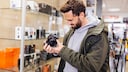 Man Looks at a Camera in the Store