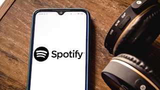 Spotify App to Get Home Feed and Smart Shuffle: Spotify Logo on Smartphone Next to Headphones