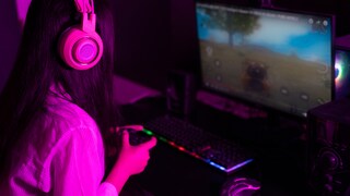 Cloud Gaming Stock Image: Woman with Controller at PC