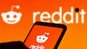 Smartphone with Reddit icon on an orange background