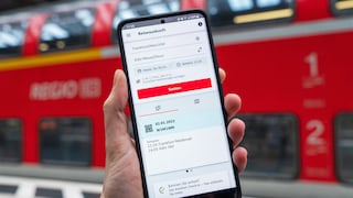 Smartphone with DB Navigator in front of a regional train