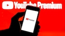 YouTube Premium Price Increase: YouTube Premium Logo on Phone Against Red YouTube Background