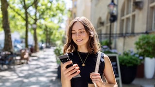 Improve and Extend Smartphone Battery Life: Young Woman on the Street in the Sun with Smartphone