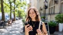 Improve and Extend Smartphone Battery Life: Young Woman on the Street in the Sun with Smartphone
