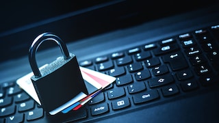 Stock Image: A padlock symbolically secures bank cards against a dark background