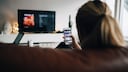 Android TV Malware: Woman with Smartphone in Front of TV
