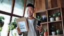 Man with Package and Smartphone in Hand