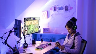 FPS vs. Hz: Teenager with Smartphone at Gaming Monitor