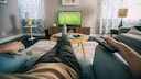 Two people watch sports on TV