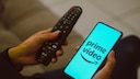 Amazon Prime Video Advertising: Service Logo on Smartphone Next to TV Remote