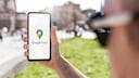 Person holds a smartphone with Google Maps in hand.