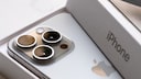 An iPhone 15 Pro with packaging.