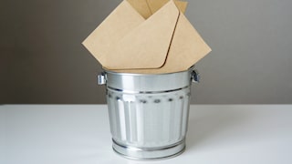Envelopes are in a trash can.