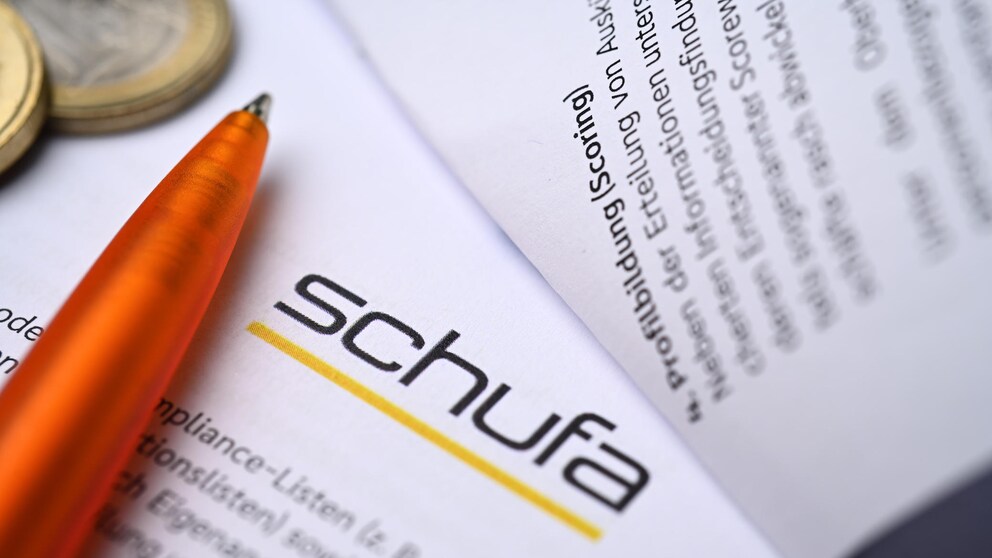 Schufa documents next to a pen and coins.