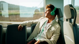 Stock photo: Man on a train listening to music through headphones.