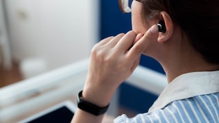 Woman Has Bluetooth Earbuds in Her Ear
