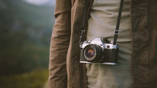 Someone has a compact camera on a strap around their neck