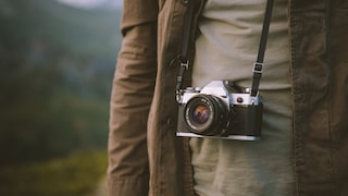 Someone has a compact camera on a strap around their neck