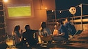 Stock photo: A group of friends watching soccer projected onto a screen.