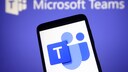 Microsoft Teams logo on a smartphone, with the program's name in the background.