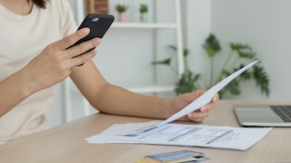 Stock image: Woman scans a bill using a PDF scanner app on her smartphone.
