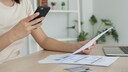Stock image: Woman scans a bill using a PDF scanner app on her smartphone.