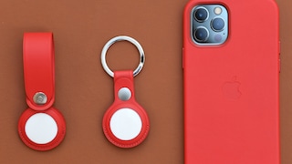 Apple AirTags next to an iPhone 12