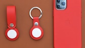 Apple AirTags next to an iPhone 12