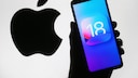 Apple logo and iOS 18 icon on a cell phone display