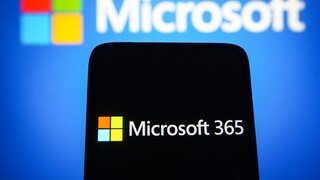 Microsoft 365 on a cell phone, with the Microsoft logo behind it
