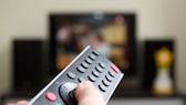 Person points to TV with remote control