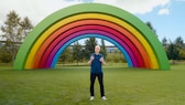 Apple boss Tim Cook in front of a rainbow