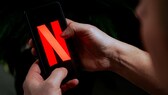 Person holds smartphone with Netflix in hands