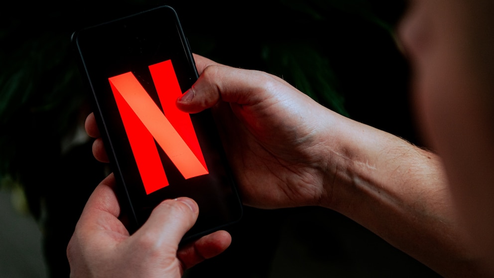 Person holds smartphone with Netflix in hands