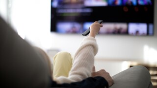 Woman with Streaming Remote in Front of TV