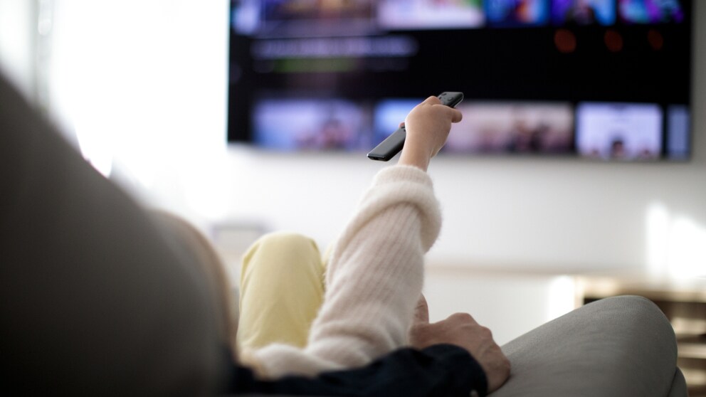 Woman with Streaming Remote in Front of TV