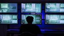 Person sits in front of several monitors
