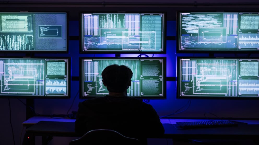 Person sits in front of several monitors