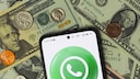 WhatsApp on a smartphone on a pile of US money