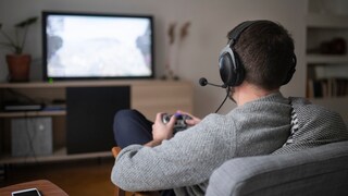 A man sits in front of the TV playing video games.