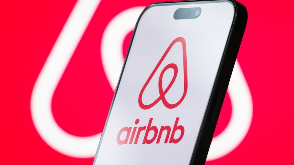 Airbnb Logo on a Smartphone and in the Background
