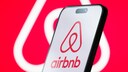 Airbnb Logo on a Smartphone and in the Background