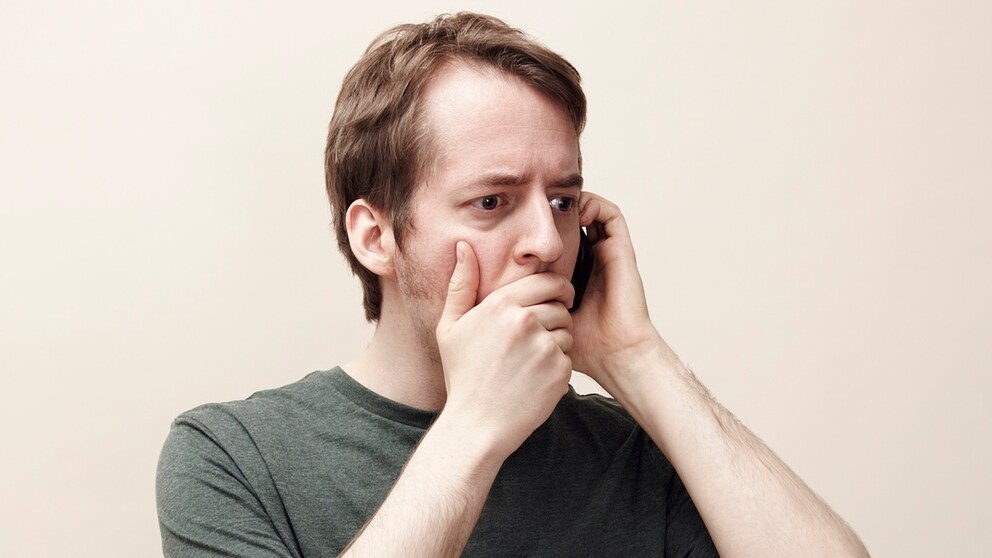 Man on the phone with a shocked expression