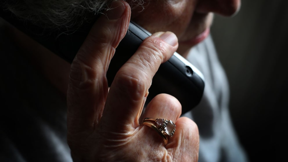 An elderly woman is on the phone
