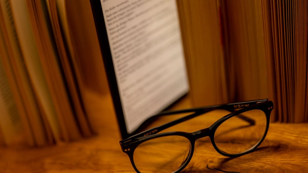 E-book reader sits among books on a table