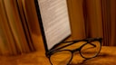 E-book reader sits among books on a table