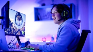 Young man sits in front of the computer and streams live
