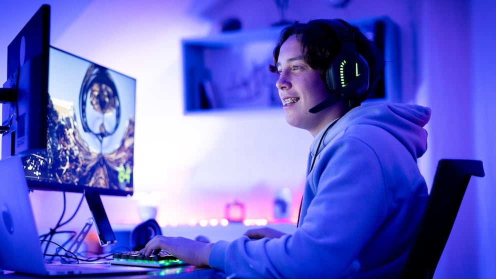 Young man sits in front of the computer and streams live