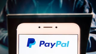 PayPal logo on a screen, with a suspicious person in the background