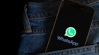 Smartphone with WhatsApp logo in a pants pocket